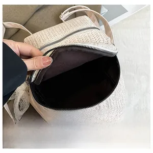 Detail display showing the large capacity and dark fabric lining of the straw backpack