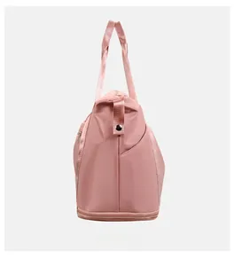 Detail view of pink travel bag showing side pocket and independent bottom shoe compartment