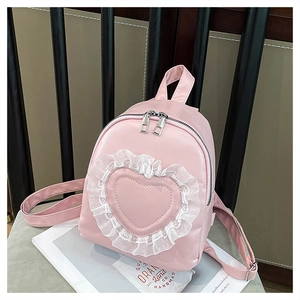 Detail of pink mini backpack with heart stitching and white lace trim on a book