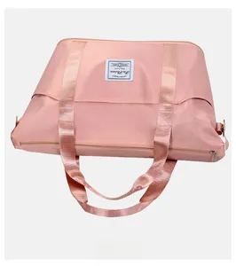 Detailed back view of the pink waterproof nylon travel bag with sturdy dual handles