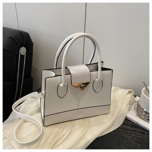 Close-up of white crossbody bag with golden buckle and textured pebble leather detail