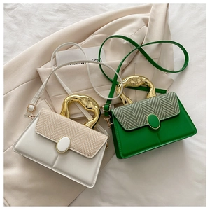 Detail of woven chevron flap and gold wave-textured handle on chic square handbags
