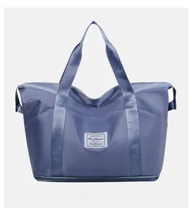Close-up of fog blue travel bag with widened handles and expandable bottom zipper layer