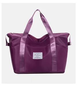 Front view of large purple waterproof travel bag with reinforced handles and brand tag