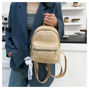 Detail of straw mini backpack with white lace, pearl charm and adjustable straps