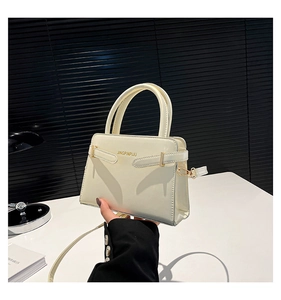 Vue détaillée du sac en cuir crème avec des ferrures dorées et le logo sur le devant