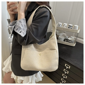 Detailed view of woven hobo bag in cream white fabric with decorative gold buckle