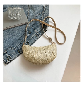 Detail of hand-woven straw crossbody bag with unique pleated texture and leather strap