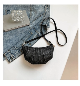 Detail of black woven hobo bag with gold hardware and adjustable leather strap