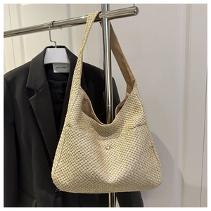 Detail of woven straw hobo bag showing fine knit texture and metal magnetic closure