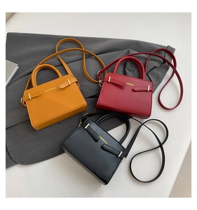 Détail de sacs à main élégants en cuir mat jaune, rouge et noir avec boucle dorée