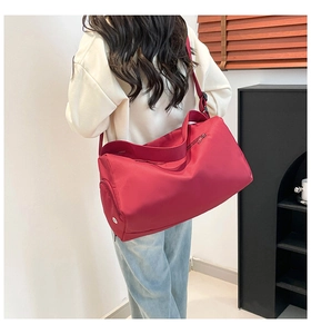 Red sports travel bag with side shoe compartment and adjustable strap for fitness use