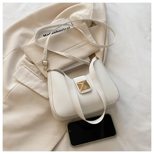 Détail d'un sac bandoulière beige en forme de lune avec rivet doré et sangle réglable