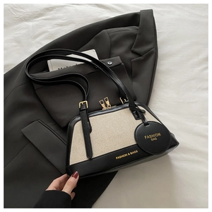 Close-up of contrast color canvas texture and black leather strap with gold hardware