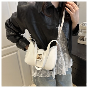Gros plan d'un sac bandoulière blanc en cuir avec une boucle carrée en métal doré