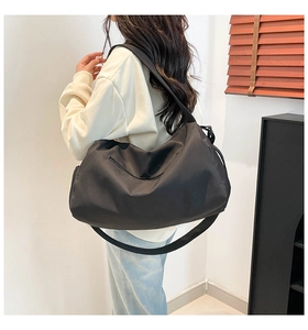 Detail of waterproof black nylon travel bag with wide shoulder strap and matte finish