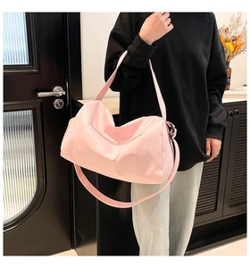 Detail of cherry pink waterproof nylon gym bag featuring reinforced handles and strap