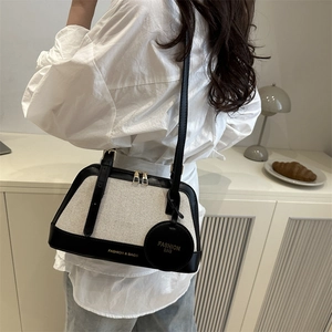 Chic two-tone Boston bag in cream canvas and black leather with adjustable shoulder strap