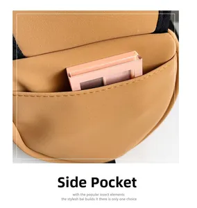 Detail view of the side pocket on a brown matte cylinder bag showing storage space