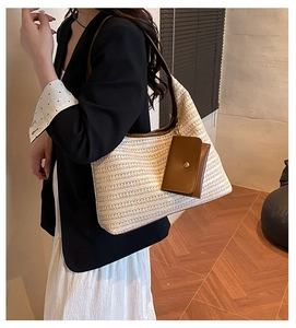 Detail of woven straw tote bag with brown leather trim and matching small hanging pouch