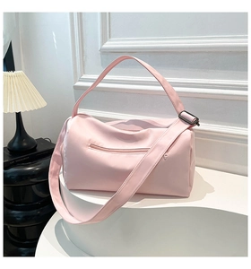 Detail of light pink waterproof nylon travel bag featuring front zipper and adjustable strap