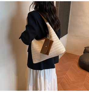 Close-up of a woven tote bag featuring deep brown leather straps and a matching pouch