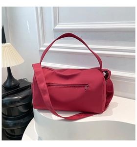 Detail of red nylon yoga bag with functional zipper pocket and wide woven strap