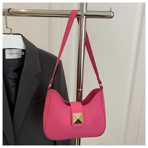 Détail du sac hobo rose fuchsia avec un clou carré doré et une texture en cuir élégante
