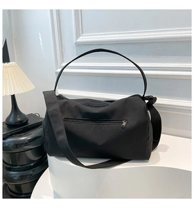 Detail of black nylon travel bag featuring a rear zipper pocket and dual shoulder straps