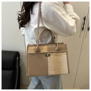Detail of light brown and cream faux crocodile tote with gold rotating metal lock