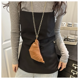 Detailed close-up of brown croissant-shaped leather mini bag with gold chain strap