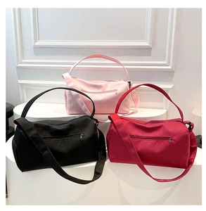 Detailed display of gym bags in pink, red, and black with adjustable shoulder straps