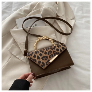 Detail der Leopardenmuster-Klappe und des eleganten gedrehten Goldmetallgriffs der Tasche