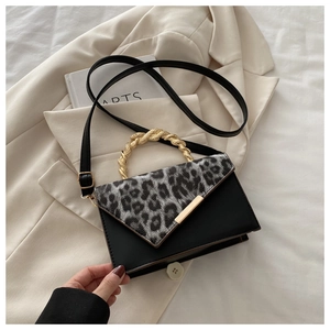 Detailansicht der Handtasche mit Leopardenmuster und goldenem Metallgriff