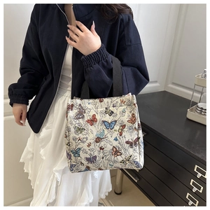 Detailed view of the linen tote bag with colorful butterfly jacquard pattern and black handles