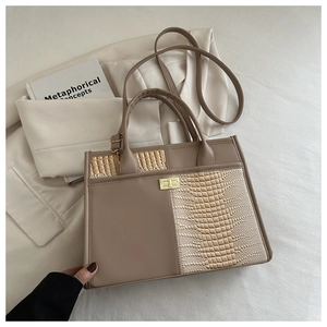 Detail of latte-colored tote bag with faux crocodile texture and gold hardware lock