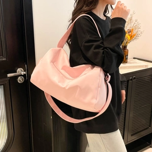 Pink waterproof yoga fitness travel bag shown in a cozy interior setting on a model