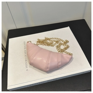 Detailed view of pale pink croissant bag with vertical quilting and gold chain