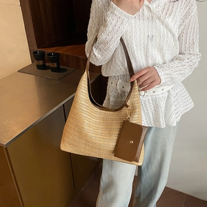 Straw hobo tote bag with brown leather strap and mini coin pouch on female model