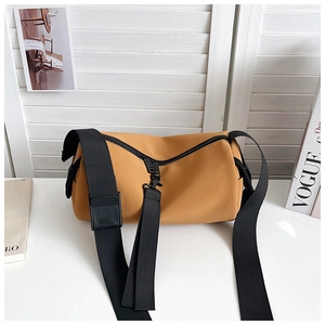 Macro detail of mustard yellow matte PU leather barrel bag with black nylon strap and buckle
