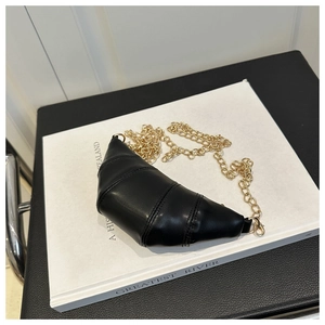 Close-up of black PU leather croissant bag with gold chain and quilted stitch details