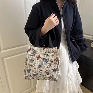 Minimalist woven jacquard tote bag with colorful butterfly patterns and black handles