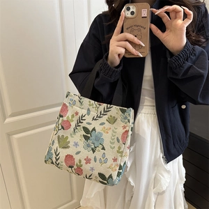 Artistic floral canvas tote bag with colorful flower patterns and black handles for daily use