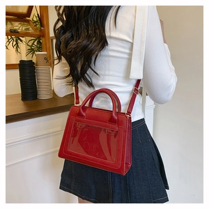 Detailed view of red crossbody bag with clear window and adjustable shoulder strap