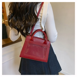Detail view of a dark red commuter bag with a clear card slot and adjustable strap
