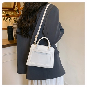Close-up of white PU leather crossbody bag with minimalist stitching and gold buckle