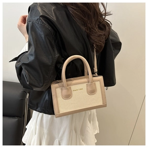 Detail of beige canvas and leather crossbody bag with golden Amety 1985 logo