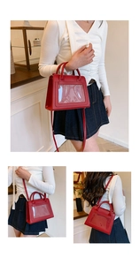 Detail view of red structured handbag with transparent window and adjustable strap