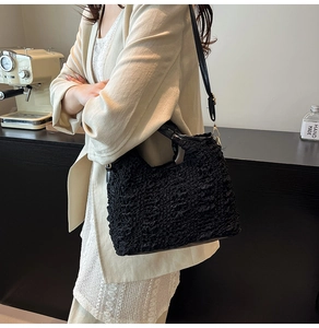 Détail du sac à main noir en tissu bulle avec texture gaufrée et bandoulière en cuir
