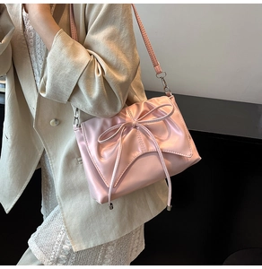 Vue détaillée d'un sac à bandoulière rose avec nœud élégant en cuir synthétique de qualité